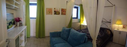 a living room with a blue couch and a fireplace at Morrovalle LOVE in Morrovalle