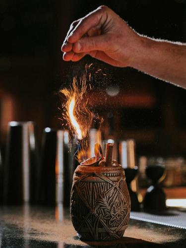 a person is holding a fire coming out of a vase at Three House Hotel in Funchal