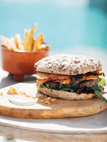 a sandwich on a plate with a bowl of fries at Three House Hotel in Funchal