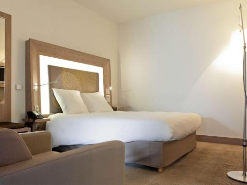 a bedroom with a large white bed in a room at Novotel Toulouse Centre Wilson in Toulouse