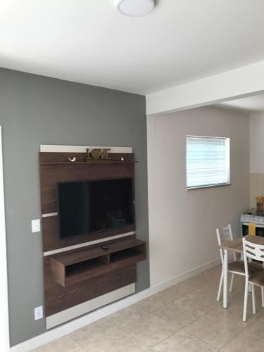 uma sala de estar com uma televisão de ecrã plano na parede em Apartamento Cantinho da Serra em Nova Friburgo