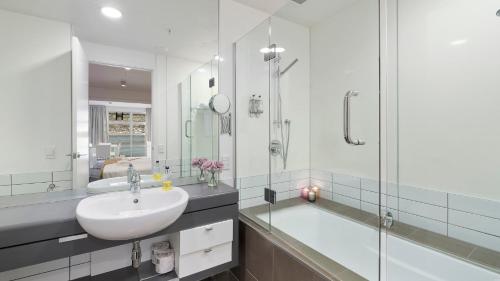 a white bathroom with a sink and a shower at Marina Views - Apt 207 in Queenstown