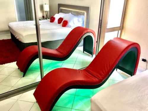a red chair in a room with a mirror at Private Apartment at Maré St Clair Hotel in San Juan