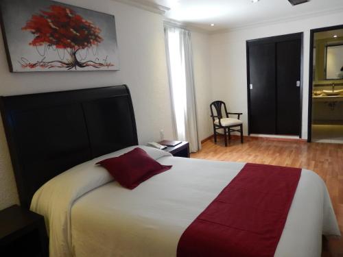 um quarto com uma cama grande e uma almofada vermelha em Roma Guadalajara in downtown em Guadalajara
