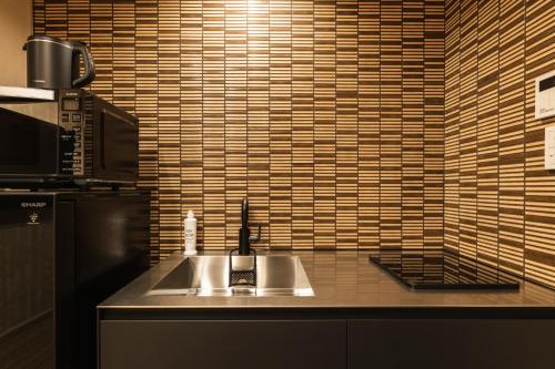 a kitchen counter with a sink and a microwave at GRAND BASE Urakami in Nagasaki