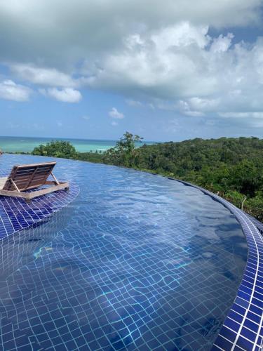 a swimming pool with a bench on top of it at Villas do Pratagy CocoBambu in Maceió