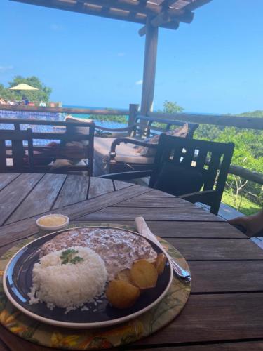 um prato de arroz e comida numa mesa de madeira em Villas do Pratagy CocoBambu em Maceió