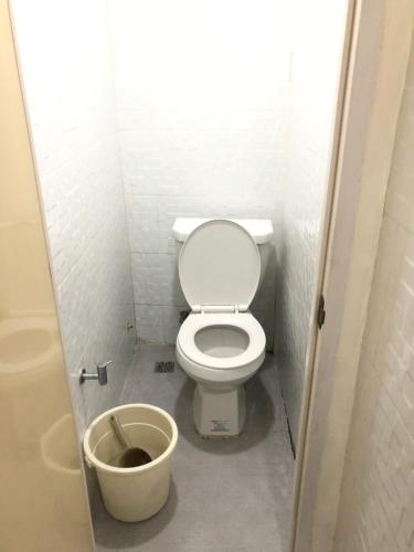 a small bathroom with a toilet and a bucket at Snoozeph in Manila