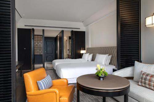 a hotel room with a bed and a couch and a table at Suning Zhongshan Golf Resort in Nanjing