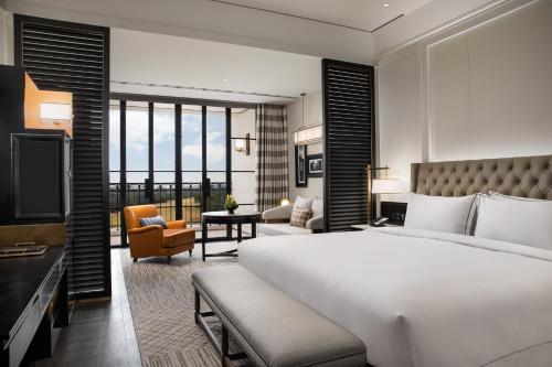 sypialnia z dużym łóżkiem i salonem w obiekcie Suning Zhongshan Golf Resort w mieście Nankin
