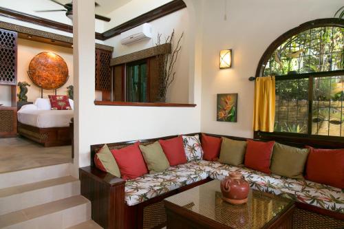 a living room with a couch and a bed at Hotel Villas Nicolas - Adults Only in Manuel Antonio