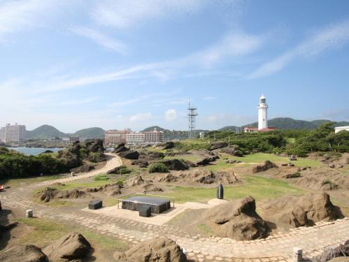 einen Park mit einem Gebäude und einem Leuchtturm auf einem Hügel in der Unterkunft Hotel Nankaiso in Minamiboso