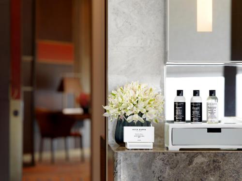 a vase of flowers sitting on a counter with bottles of alcohol at Grand Hyatt Xi'an in Xi'an