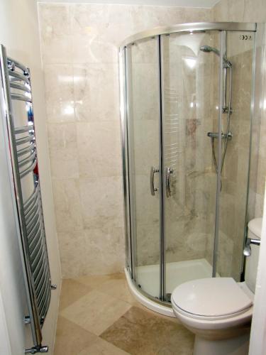 y baño con ducha de cristal y aseo. en Churchills Inn & Rooms, en Bowness-on-Windermere