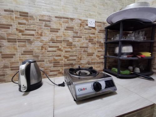 a kitchen counter with a stove and a toaster on it at Salassel Al Jabal Al Akhdar Guesthouse in Al ‘Aqar