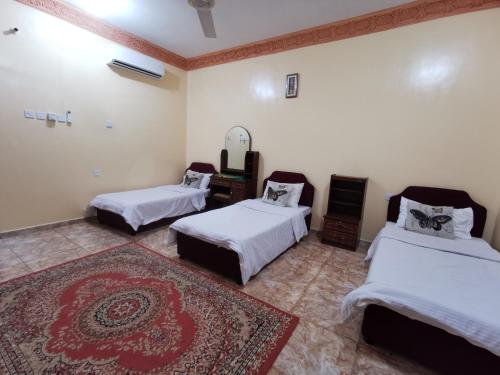 a room with two beds and a rug at Salassel Al Jabal Al Akhdar Guesthouse in Al ‘Aqar