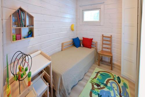 a small bedroom with a bed and a desk at ONNI Village in Ruokolahti