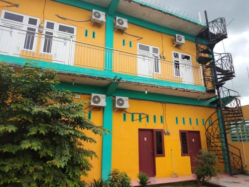 a yellow and green building with a balcony at KOST 748 AT in Delitua