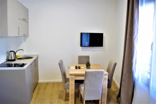 a kitchen and dining room with a table and chairs at Martinović Rooms in Budva