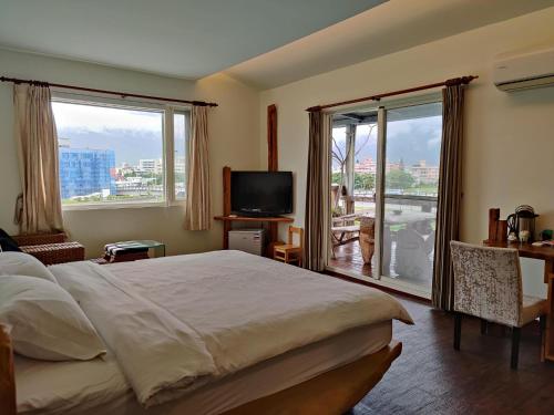 a bedroom with a bed and a large window at Two Dots On Line Homestay in Hualien City