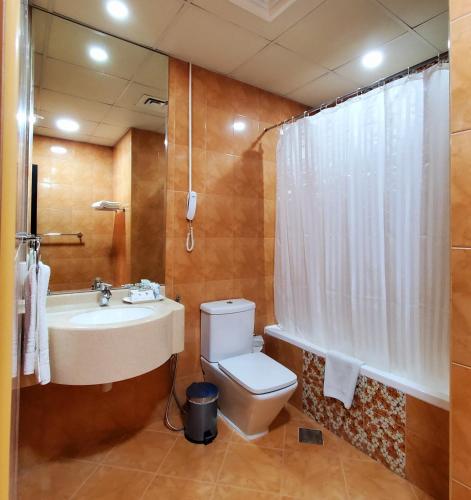 a bathroom with a toilet and a sink and a shower at Skylark Hotel Apartments AL Barsha in Dubai