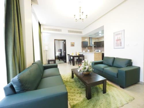 a living room with two blue couches and a table at Skylark Hotel Apartments AL Barsha in Dubai