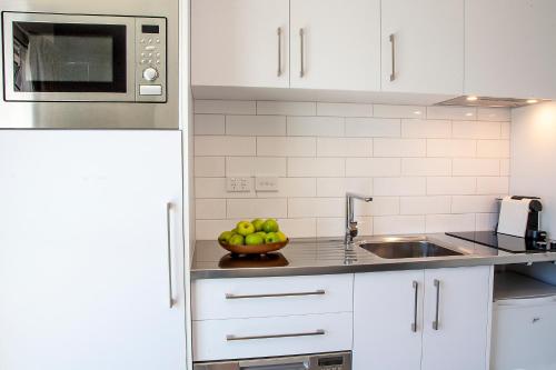 a kitchen with a bowl of apples on the counter at Sojourn Apartment Hotel - Riddiford in Wellington