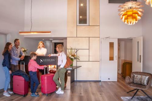 a group of people with luggage in a room at Sojourn Apartment Hotel - Riddiford in Wellington
