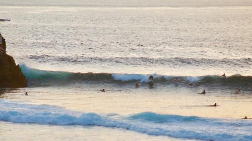 a group of people swimming in the ocean at The Palms Ceningan Hotel in Nusa Lembongan