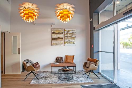 a lobby with two chairs and a table and two chandeliers at Sojourn Apartment Hotel - Riddiford in Wellington