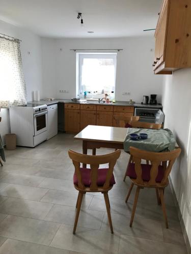 a kitchen with a wooden table and two chairs at Best for fife in Pfaffing