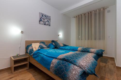 een slaapkamer met een bed met een blauw dekbed bij Binis in Zlatibor