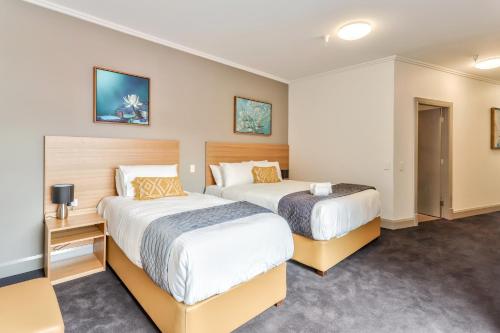 a hotel room with two beds in it at Meridian Hotel Hurstville in Sydney