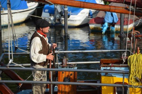 a man standing on a boat in the water at Hotel zur Brücke in Greifswald