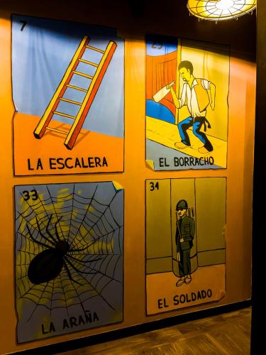 a wall with posters on it with a spider and a ladder at Cadillac Hotel Boutique in Mexico City