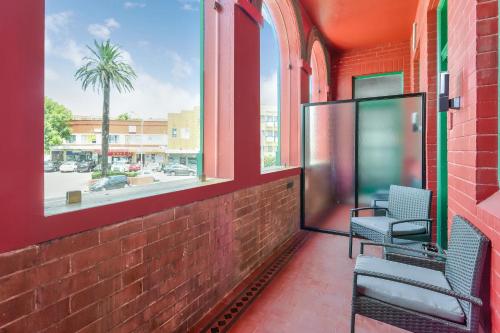 a balcony with two chairs and a window at Meridian Hotel Hurstville in Sydney