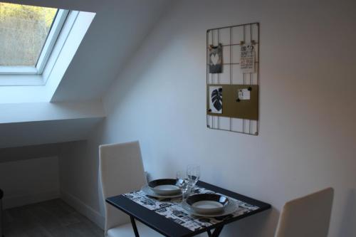 une salle à manger avec une table et des chaises et une fenêtre dans l'établissement PYRENE HOLIDAYS - Résidence Le Grand Hôtel - Appartement 4 étoiles à 2 pas des thermes de Capvern Les Bains, à Capvern