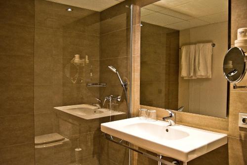 a bathroom with a sink and a shower and a mirror at BQ Augusta Hotel in Palma de Mallorca