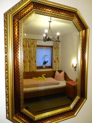 a mirror with a bed in a room at Pension Rainhof in Kitzbühel