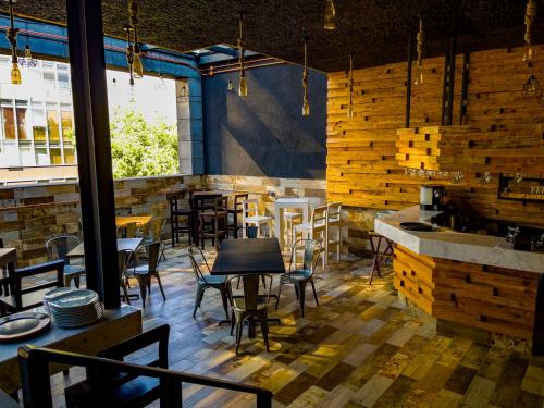 a restaurant with wooden walls and tables and chairs at Cadillac Hotel Boutique in Mexico City