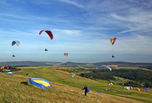 a group of people flying kites in a field at Rhöner Landhotel Haus zur Wasserkuppe in Ehrenberg