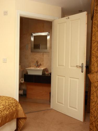 a bathroom with a sink and a white door at Churchills Inn & Rooms in Bowness-on-Windermere