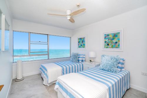 a bedroom with two beds and a large window at Pacific Plaza Apartments in Gold Coast