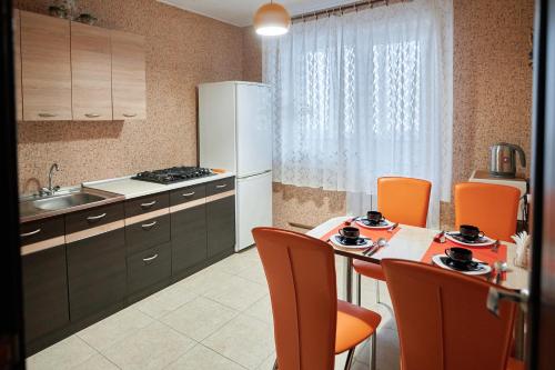 a kitchen with a table and a white refrigerator at Holiday and Travel Apartment in Brest
