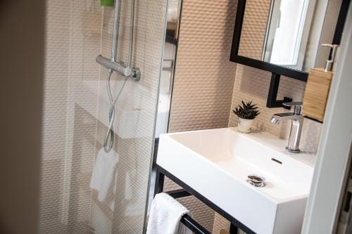 a bathroom with a white sink and a shower at Aigle d'Or - Strasbourg Nord in Reichstett