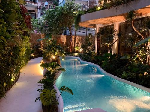 uma piscina no meio de um jardim à noite em Cityhouse - CityOasis em Cidade de Ho Chi Minh