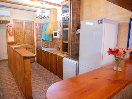 a kitchen with a white refrigerator and a wooden table at Elegant Villa in Archena + Private Pool in Archena