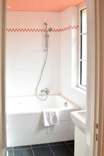 une salle de bain avec une baignoire et un lavabo dans l'établissement Villa de luxe à Gonneville-sur-Mer, à Gonneville-sur-Mer