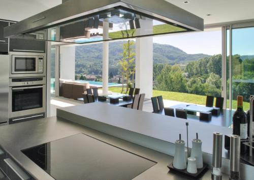 une cuisine avec une table à manger et une grande fenêtre dans l'établissement Villa d'exception à Saint Désirat avec piscine privée, à Saint-Désirat