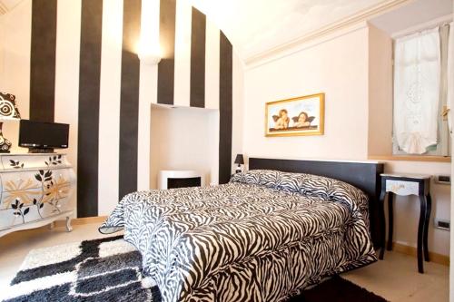 a bedroom with a bed and black and white stripes at Comfortable studio in Piazza, 30 m², fireplace & balcony in Mondovì